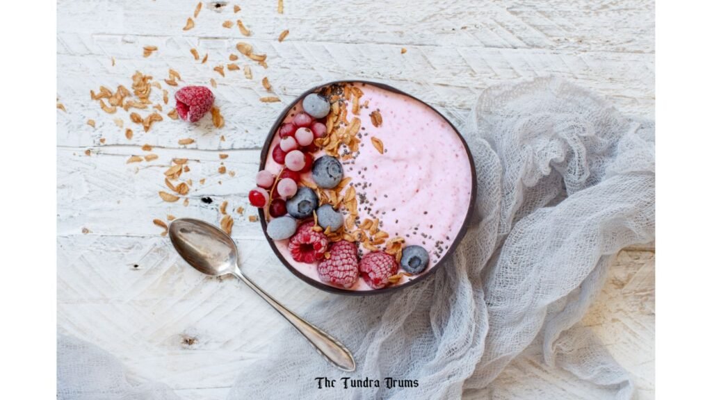 Wild berries smoothie in a bowl with a spoon on table