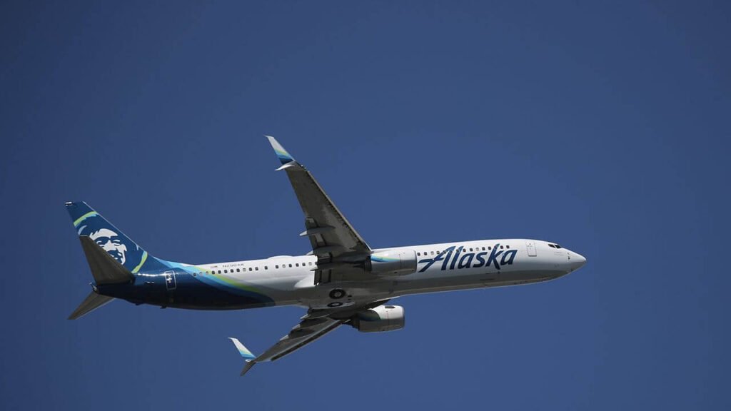 An Alaska Airlines Boeing airplane flying in the sky.