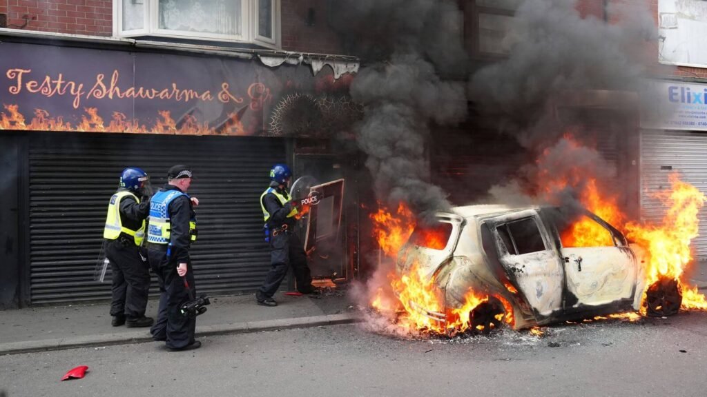 A car burns on Parliament Road as the aftermath of the riots in UK