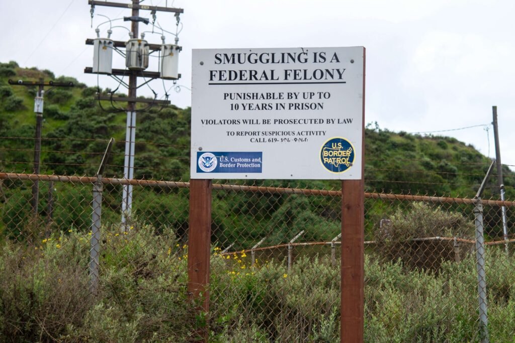 A sign warning of the severe penalties for smuggling, stating it's a federal felony punishable by up to 10 years in prison.