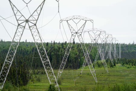 Power Outage in Alaska Disrupts Thousands Power line towers stretching across a landscape in Alaska
