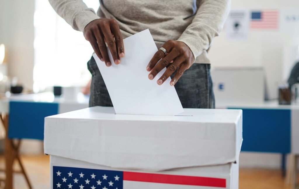 A man putting a paper in the ballot box