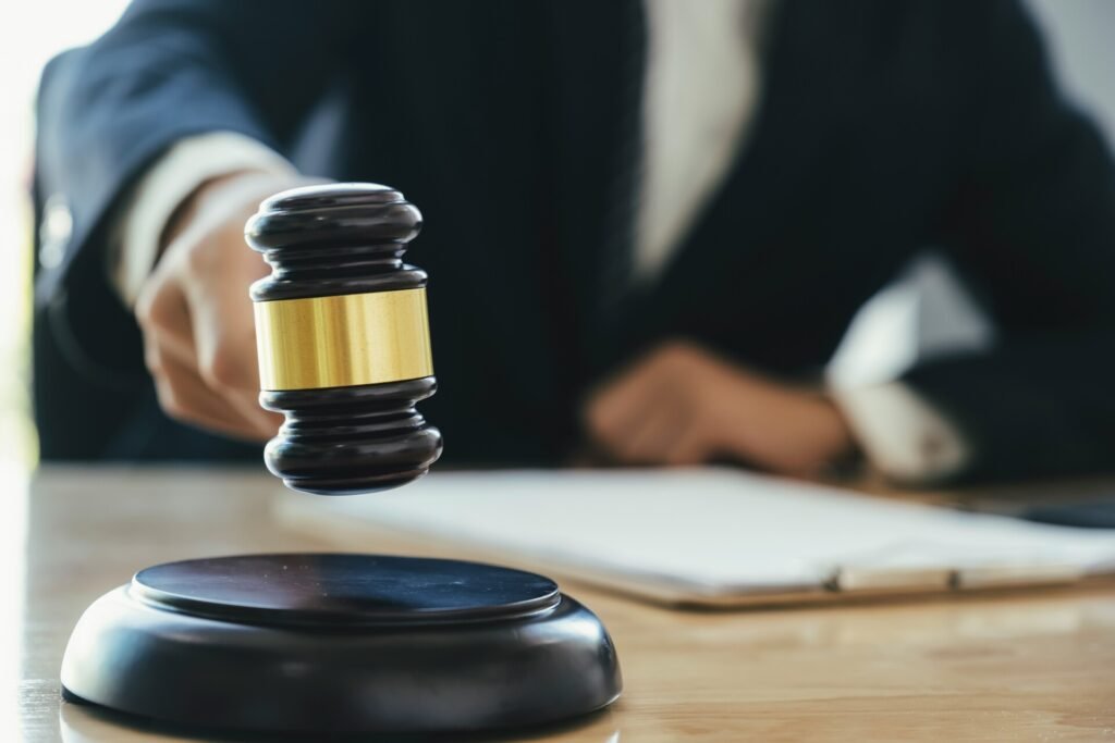 A person holding a gavel is about to strike it on a sound block.