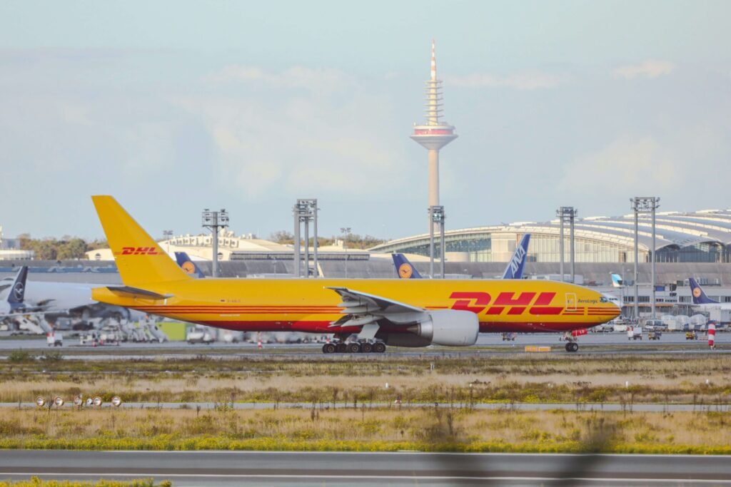 Sideview of a DHL cargo plane on the runway.