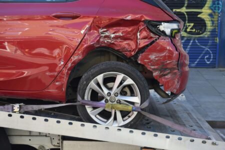 A damaged red car being towed.