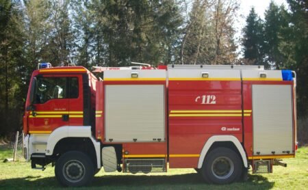 A Fire Truck is parked in front of the trees.