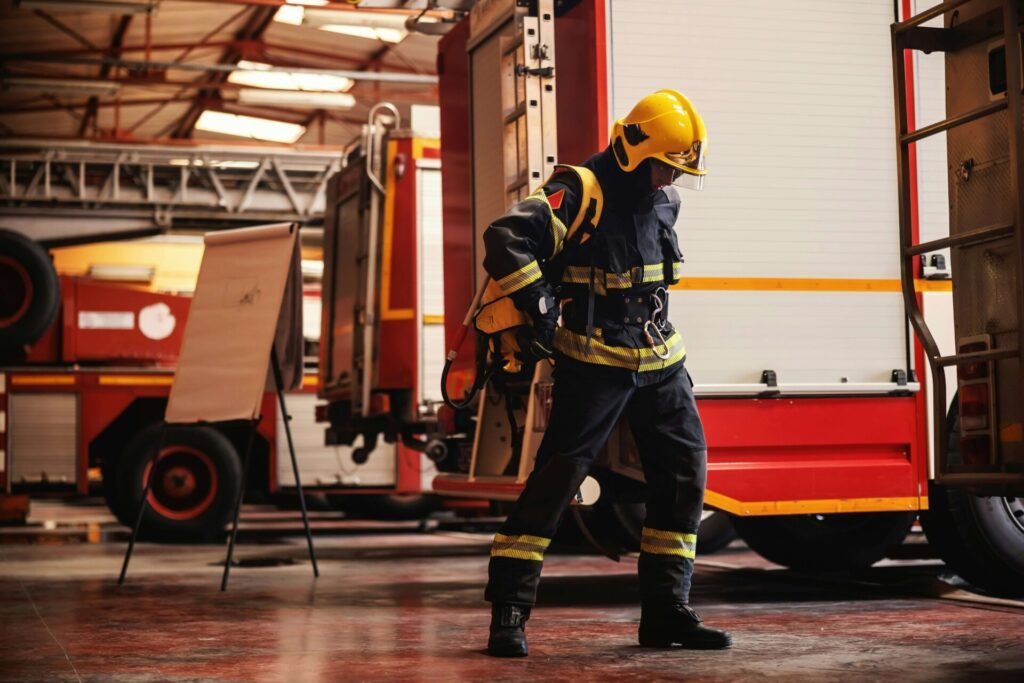 A firefighter standing in front of fire trucks.