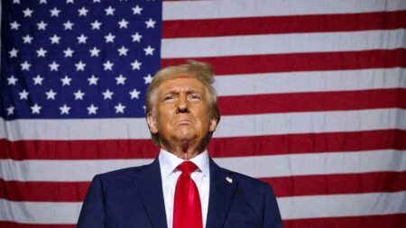 The President-elect of US, Donald Trump standing in front of the American flag.