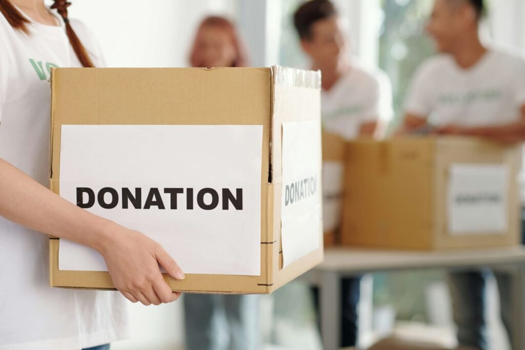 A person is holding a donation box.