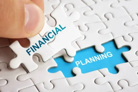 and holding piece of puzzle with words Financial Planning