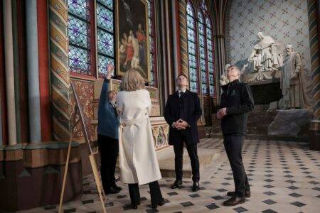 President Emmanuel Macron meets with Marie Parant, who restored wall paintings in the St Marcel's chapel at the Notre Dame cathedral.