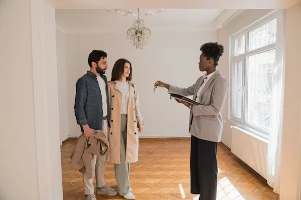 Simplifying the Home Buying Journey: How Real Estate Agents Make It Easier a couple standing next to real estate agent