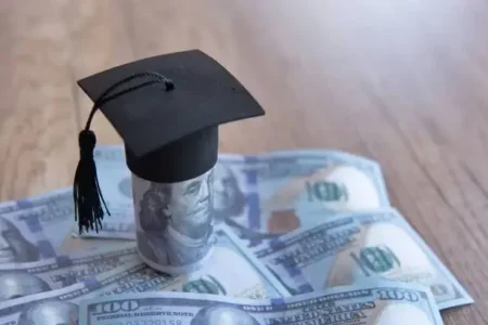 graduation cap and money on table