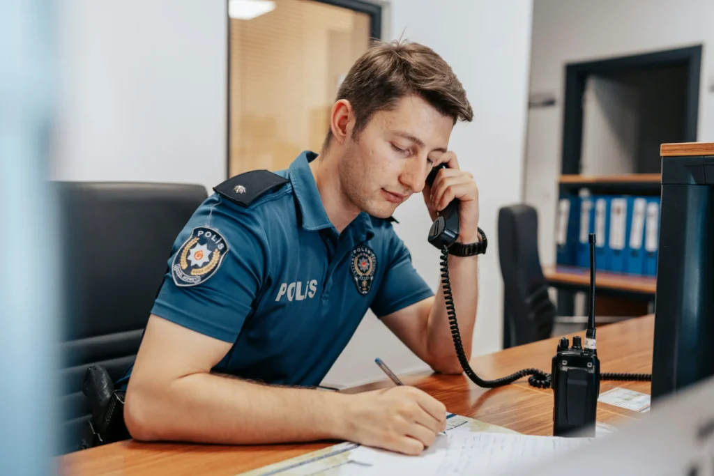 A police officer taking a call at a police station.