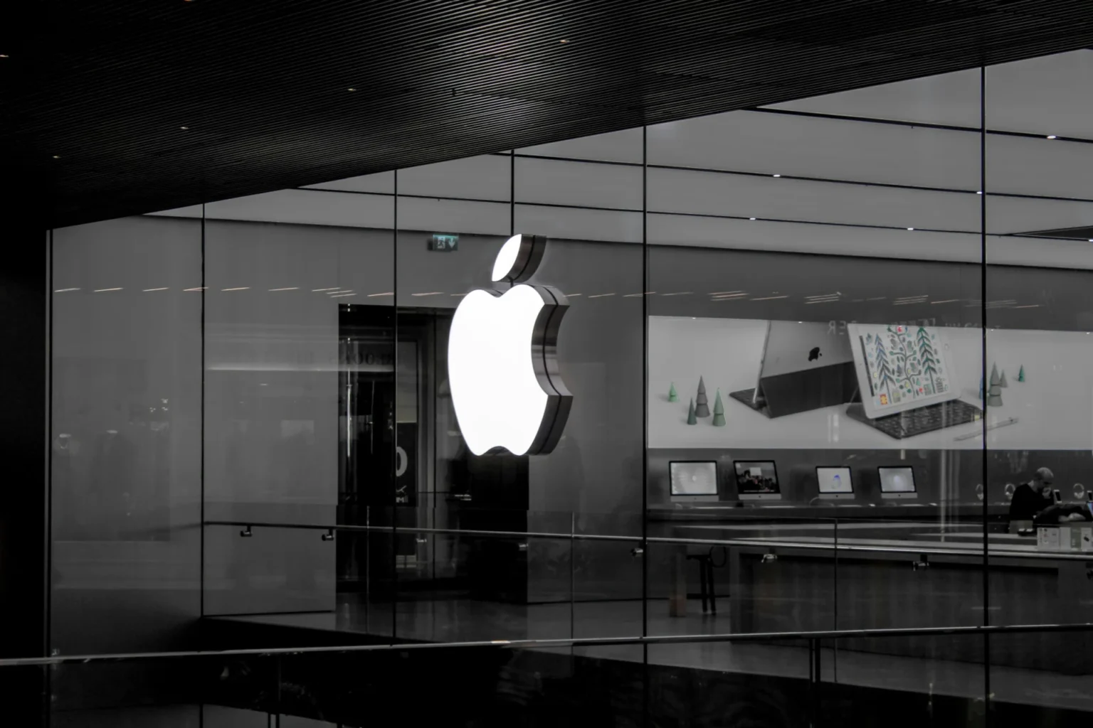 White Apple Logo on a glass wall.