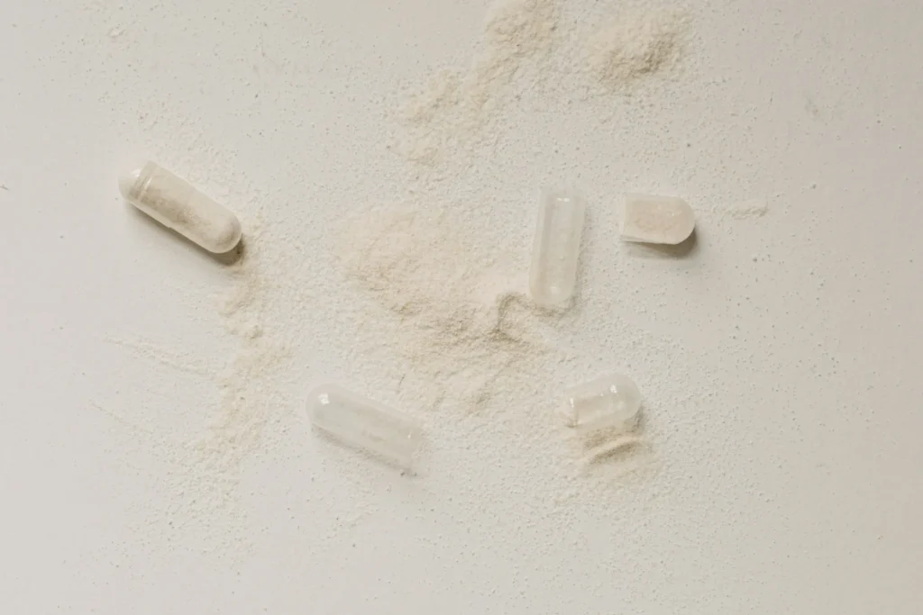 A group of pills scattered on a white surface.