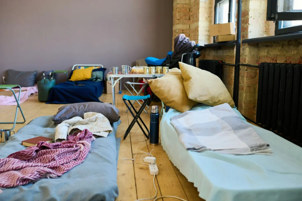 Two mattresses for refugees in a shelter with blankets.