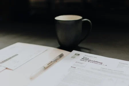 A coffee mug near a folder with tax papers.