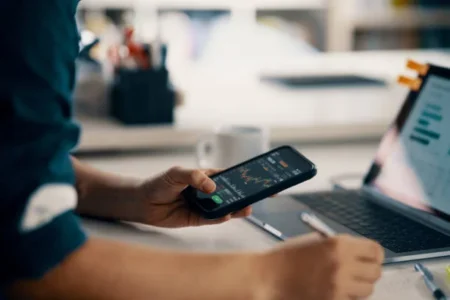 Mid adult man checking financial information on a smart phone