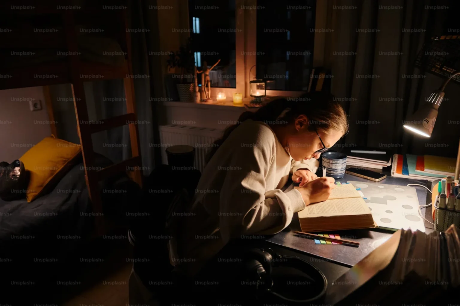 girl sitting on a desk writing in a book