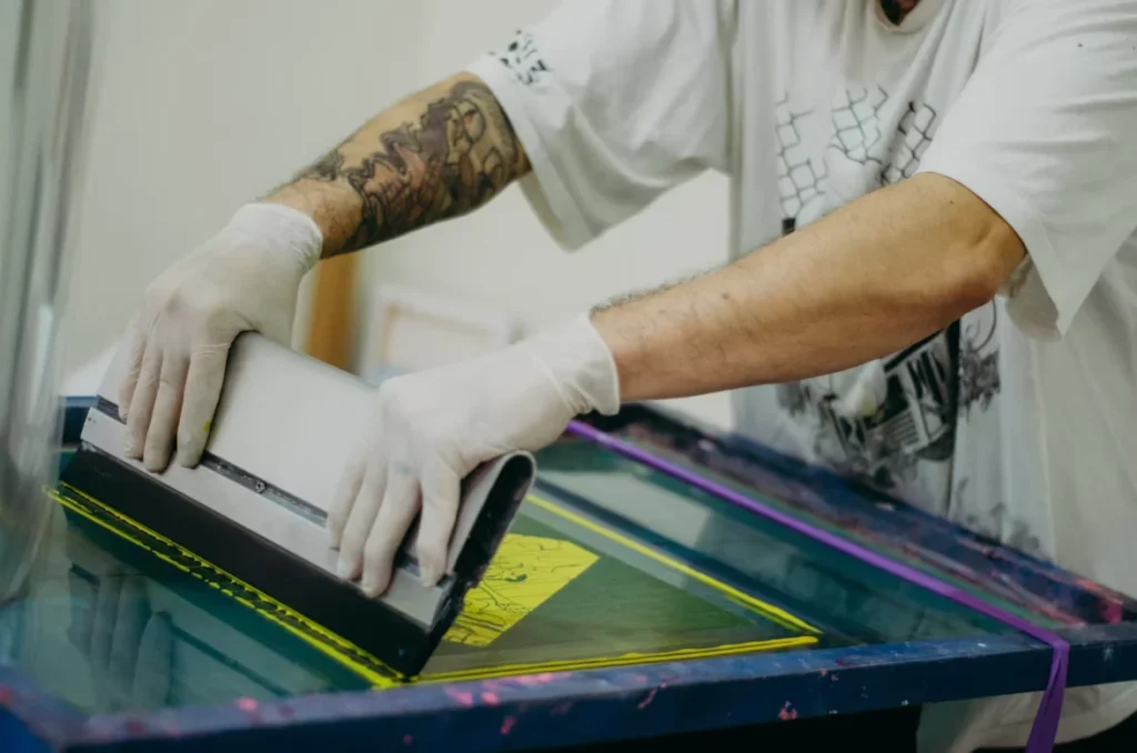 How to Get Bright Colors Through Screen Printing Techniques a man using machine