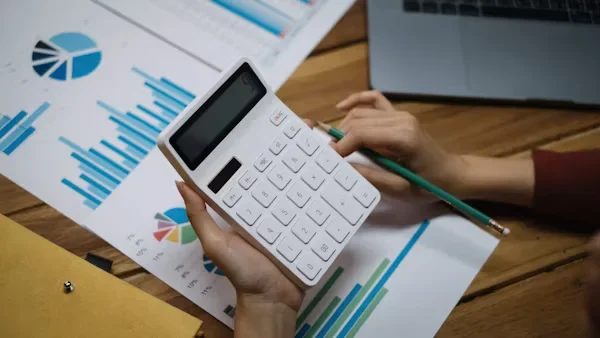 13 Ways Accountants for Marketing Agencies Improve Budget Management a person holding calculator in hands