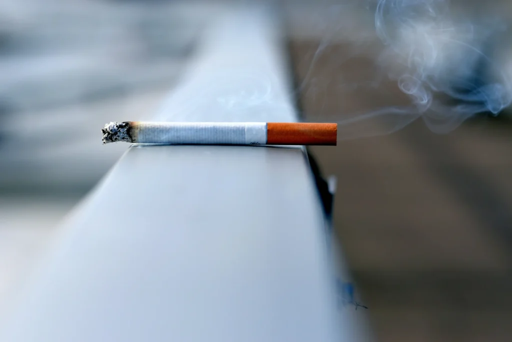 A cigarette laying on a wall.