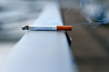 Alaska’s Smoking Decline Continues as Rural Challenges and Iqmik Use Persists A cigarette laying on a wall.