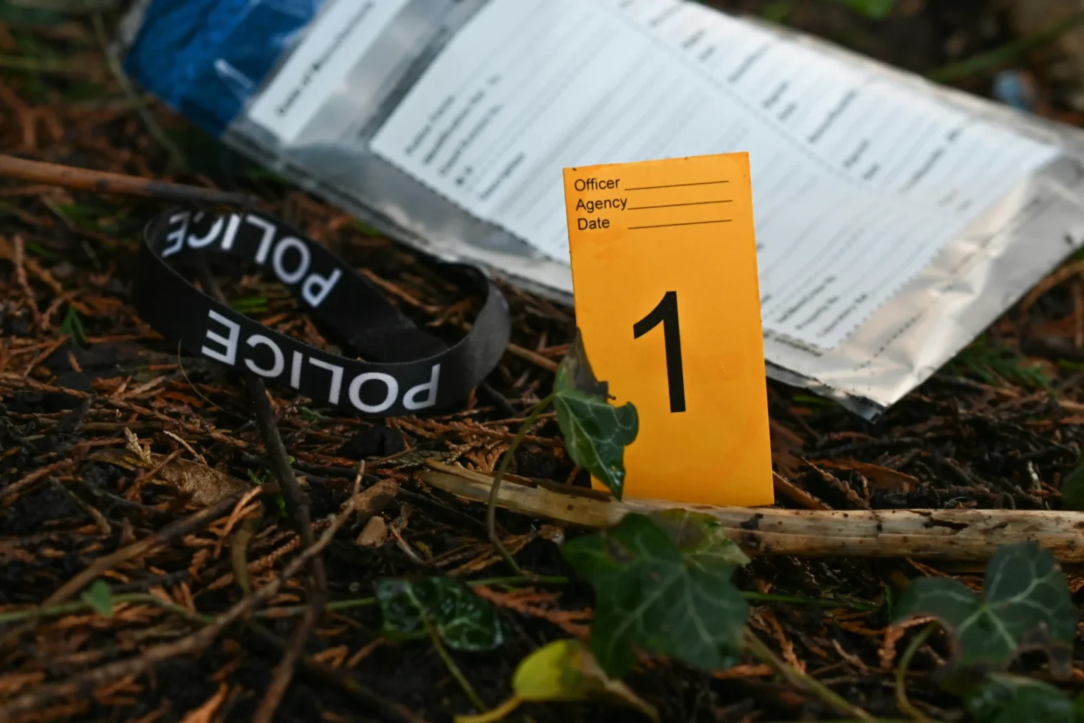 Police tape and evidence laying on the ground.
