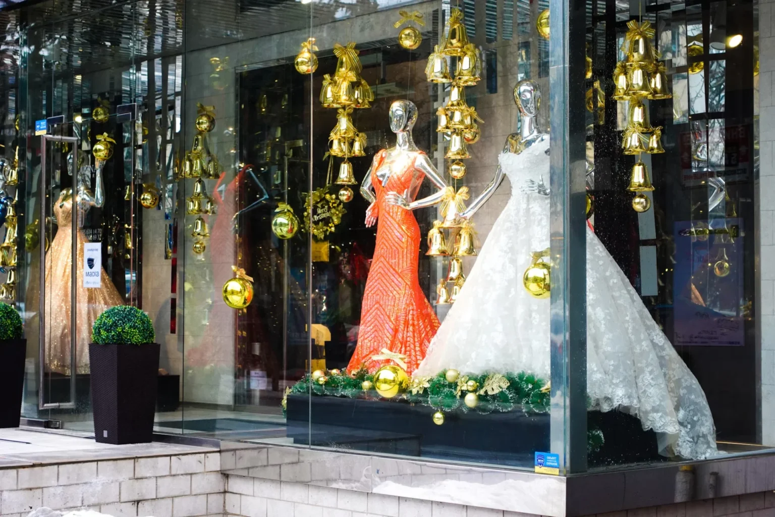 a window display with mannequins dressed in evening gown