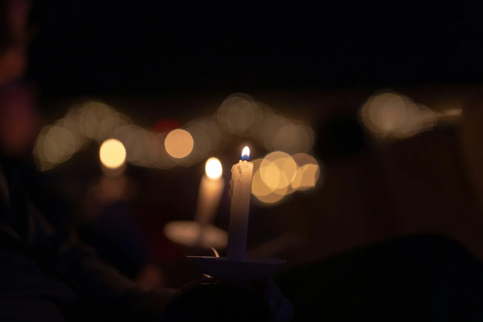 Community Honors Tony Kronos During Emotional Eagle River Vigil Candles in the dark.