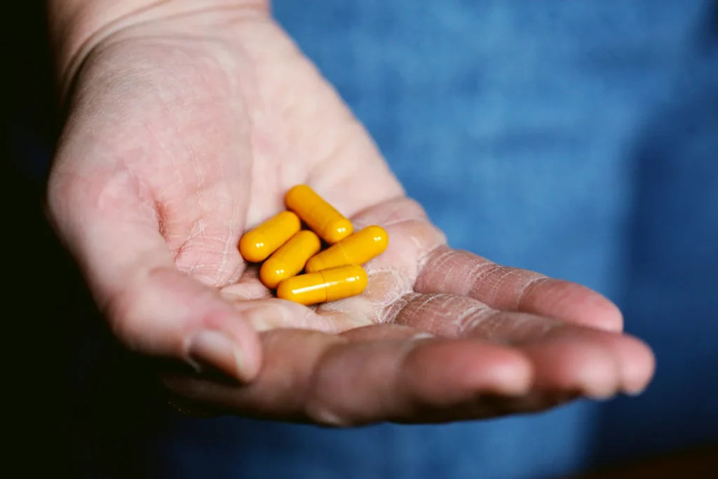 A bunch of pills in a persons hand.