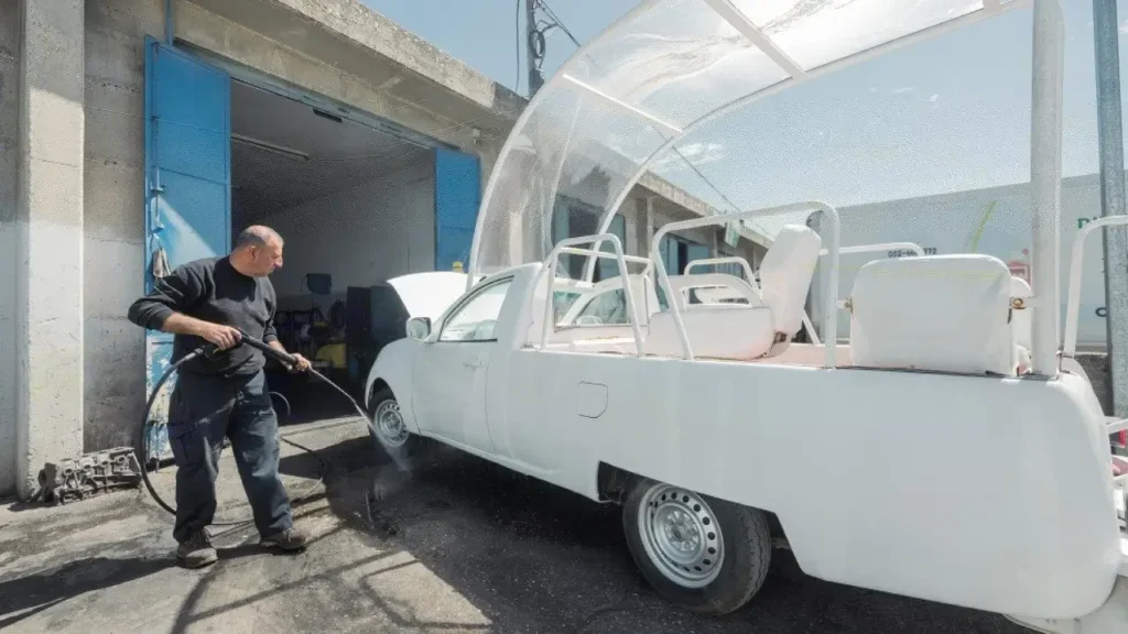 A man working on the popemobile.