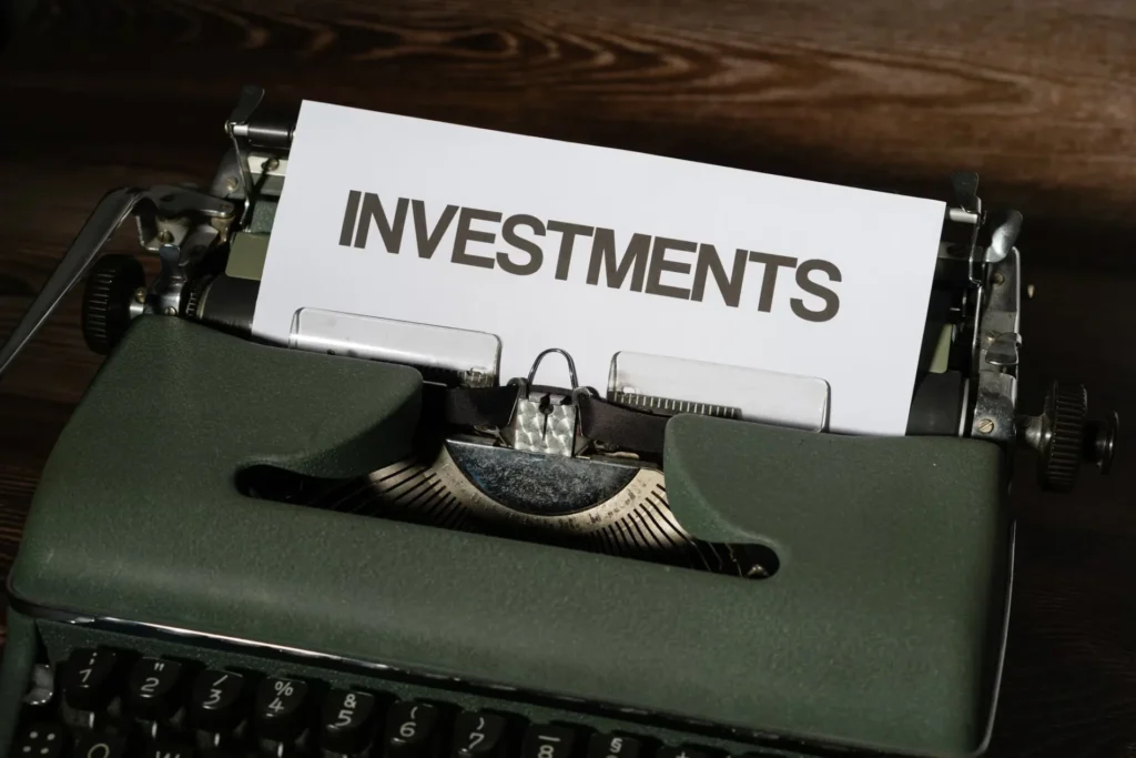 a close up photo of type writer that reads investment