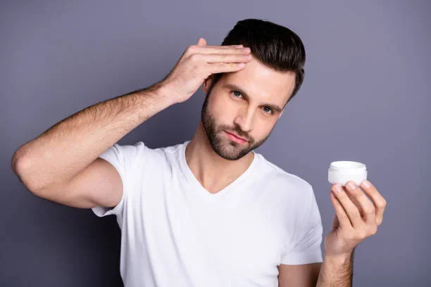 How to Apply Hair Pomades Correctly for a Perfect Look A man applying hair wax on his hairs