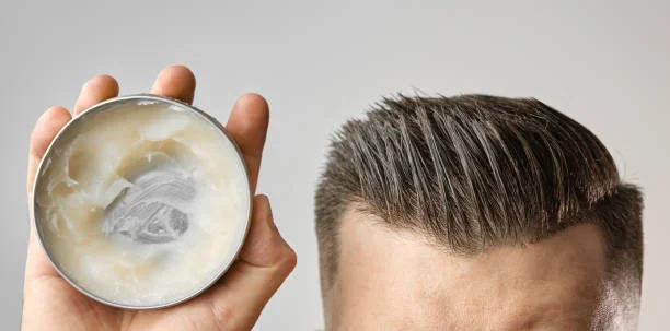 How to Apply Hair Pomades Correctly for a Perfect Look a man holding pomade tin