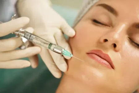 doctor holding injection near woman's face