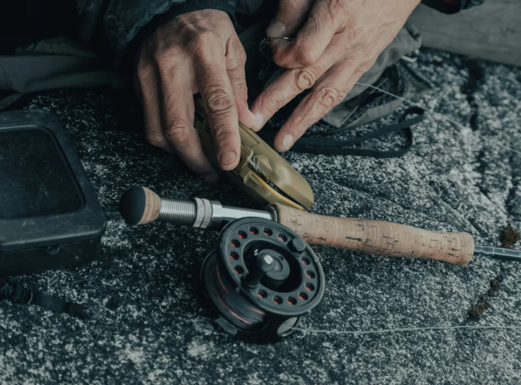 The Essential Guide to Fly Tying Vises a man holding broken wood piece