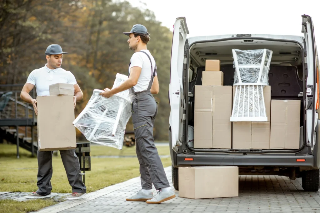 Two men are offloading furniture
