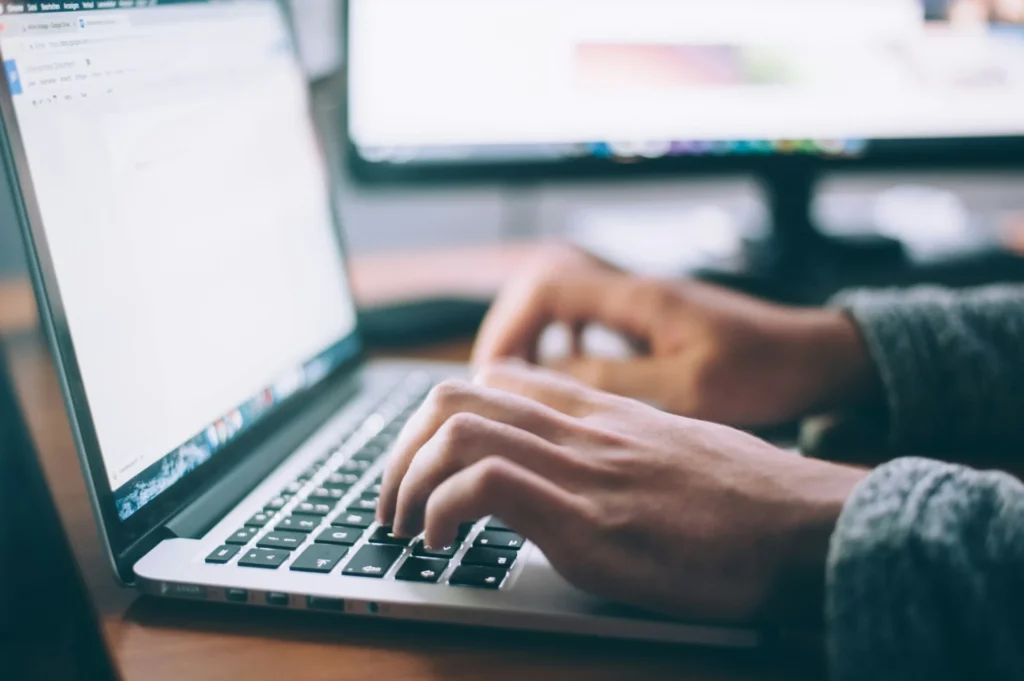 a person typing on laptop