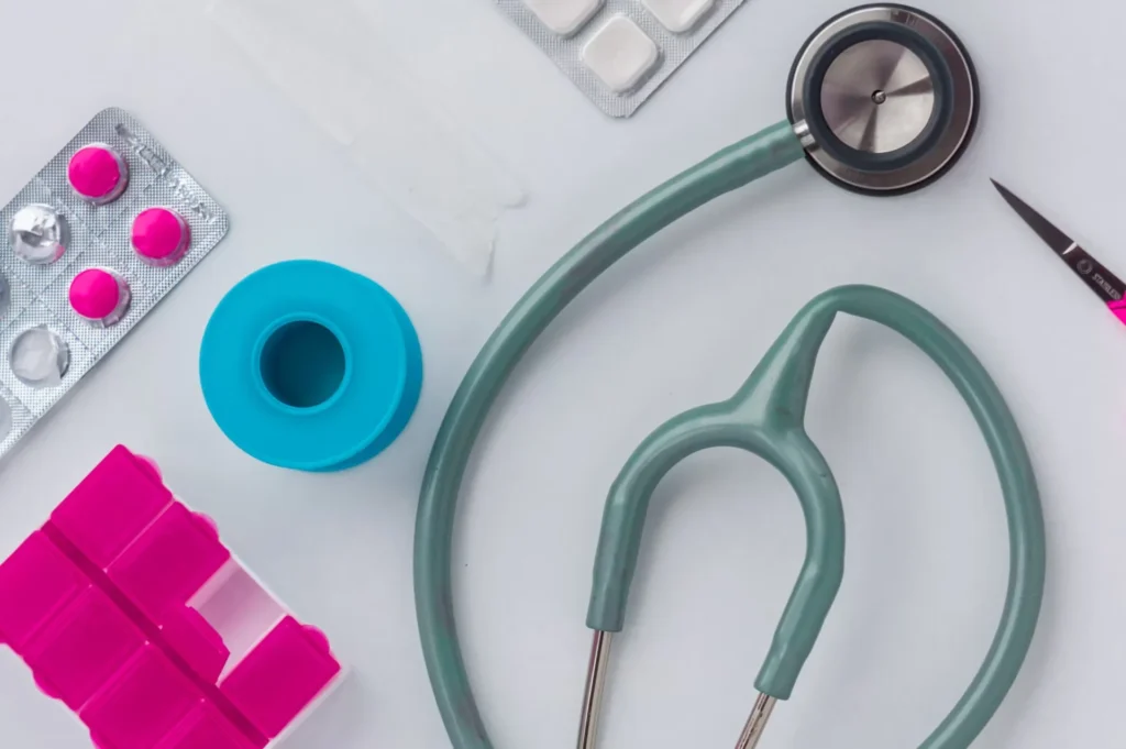 green and silver stethoscope with medicine
