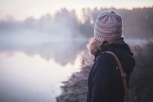 A women wearing a hat looking at water