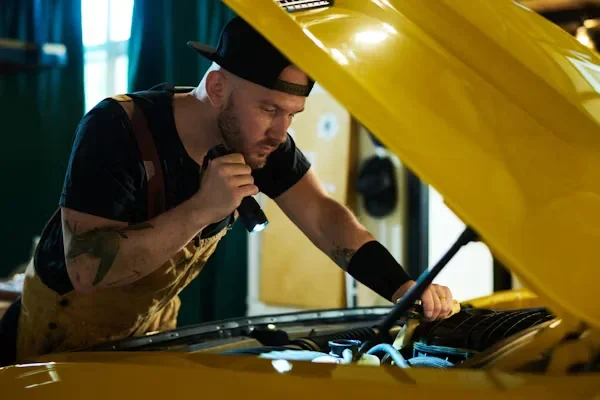 A mechanic checking cars engine