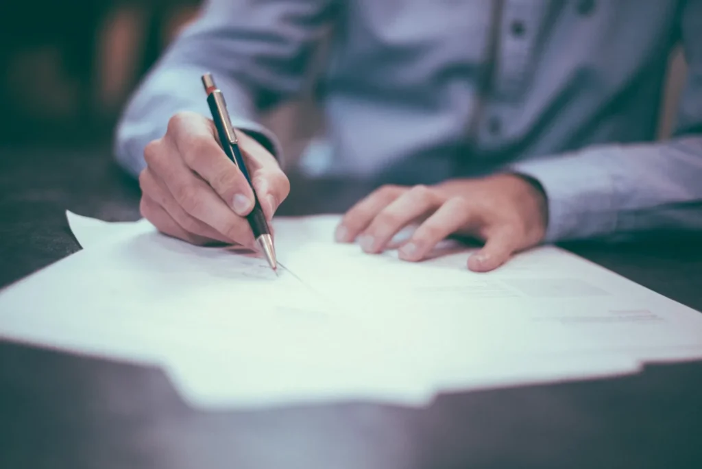 How to Spot a Low Settlement Offer After an Accident in Denver man is writing on paper