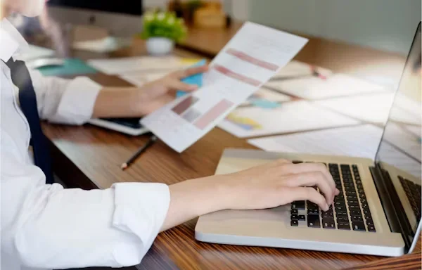How Can Businesses Stay Ahead in Lead Gen Without Burning Out? person typing on laptop keyword