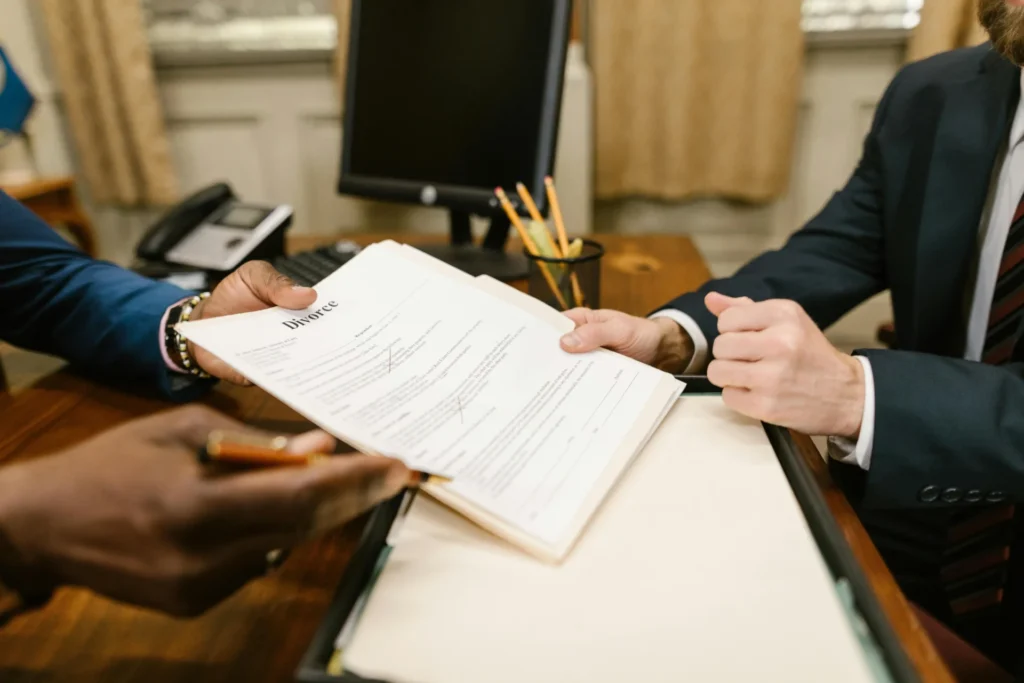a person handing over divorce papers to another man