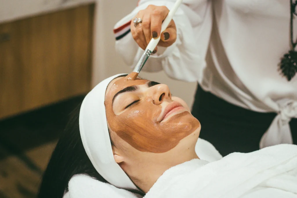 Professional Tips to Enhance Skin Care at Your Skin Clinic a woman applying mask on girls face