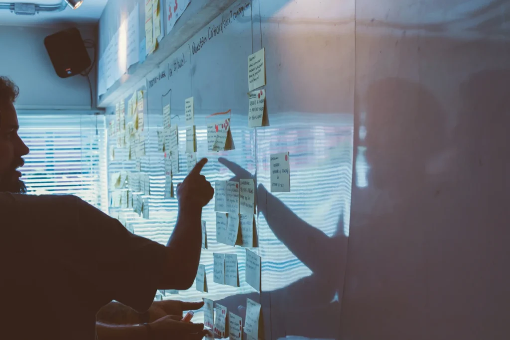 a man pointing at white board