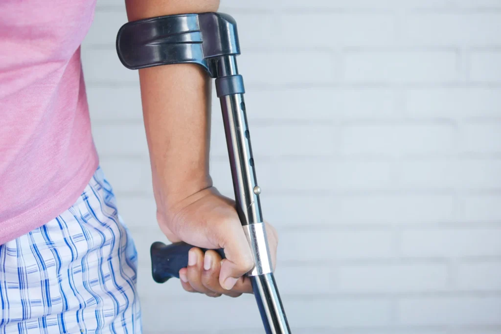 a man holding a crutch and walking cane