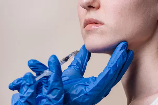 Practical Tips to Know Before Getting a Facelift woman receives a injection on her chin